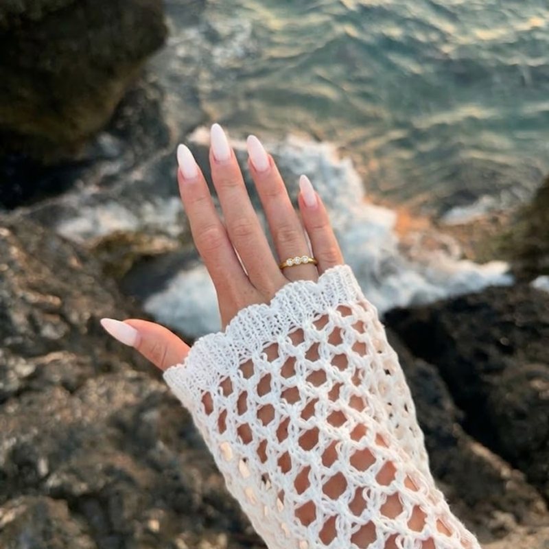 Hand wearing EE rings by the sea